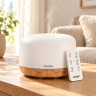 Aroma diffuser with 500 ml capacity, remote control, LED light, and wooden base in a white design.