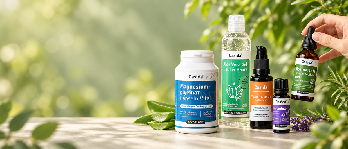 Casida Produktauswahl vor sonnigem Gartenhintergrund; eine Hand hält Rosmarinöl.