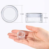 Clear 5 ml mini cream jar with screw cap, held in a hand for size reference.