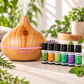 Casida Aroma Diffuser in Holzoptik mit rosa LED-Licht und sechs ätherischen Ölen auf einem Tisch