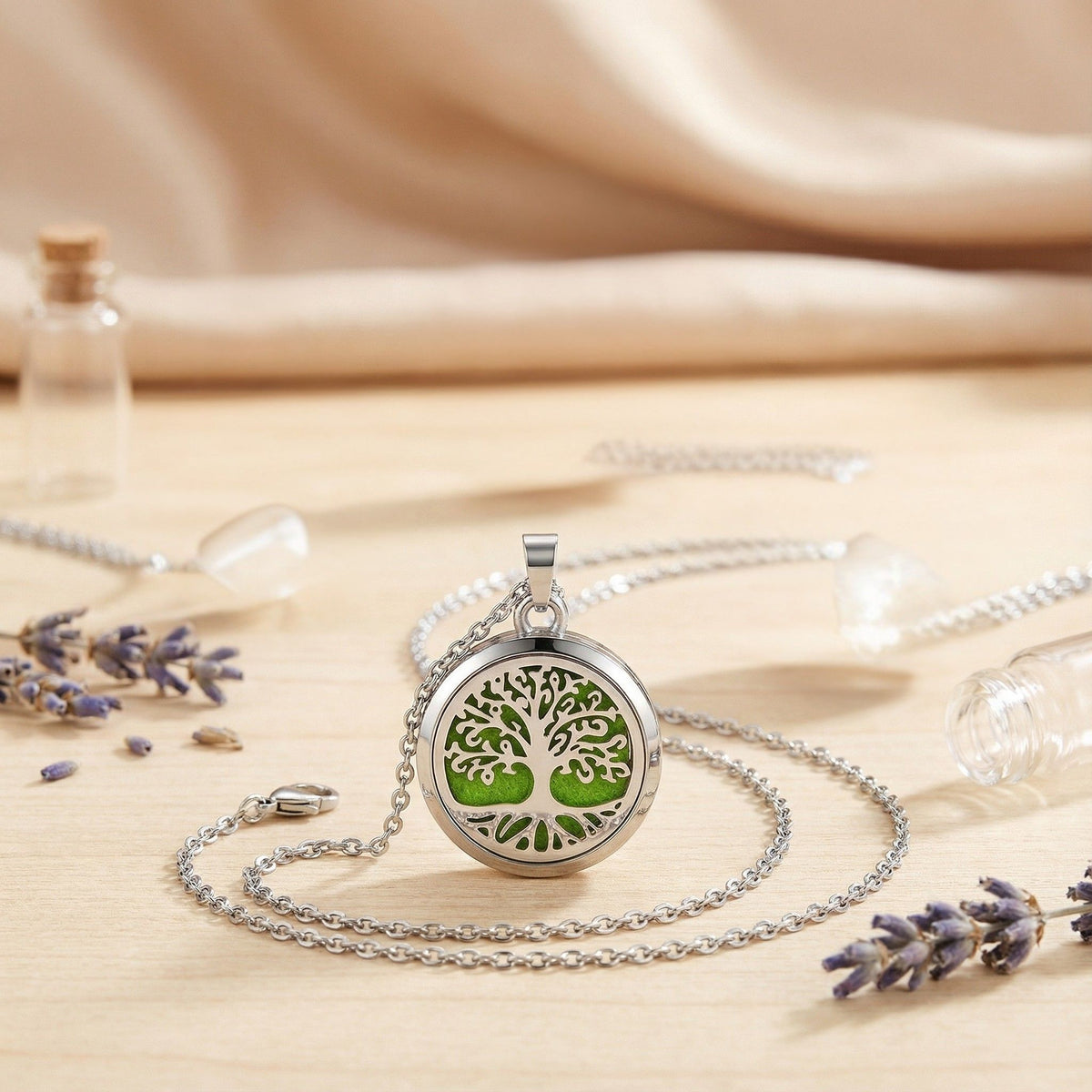 Diffuser necklace for essential oils with a green tree of life design, silver chain, and lavender accents.