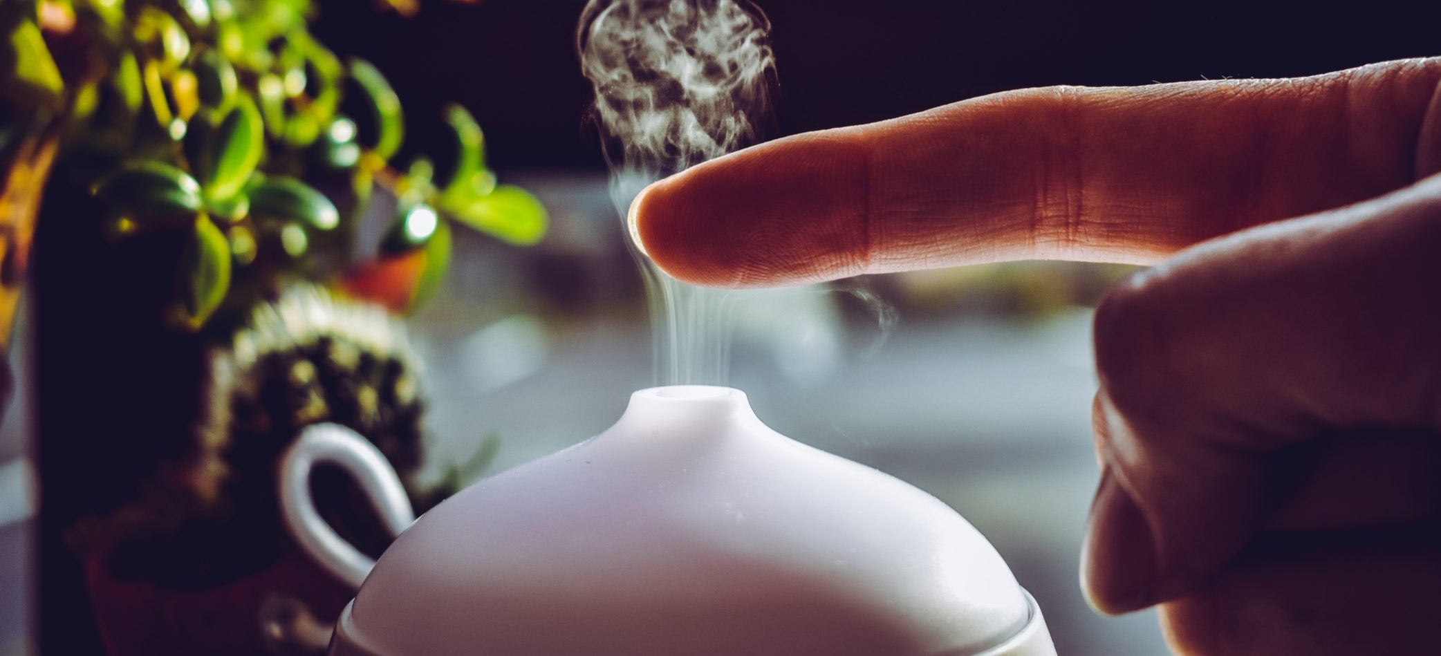 Ein Diffuser vernebelt eine Flüssigkeit ein Finger wird in den Nebel gehalten