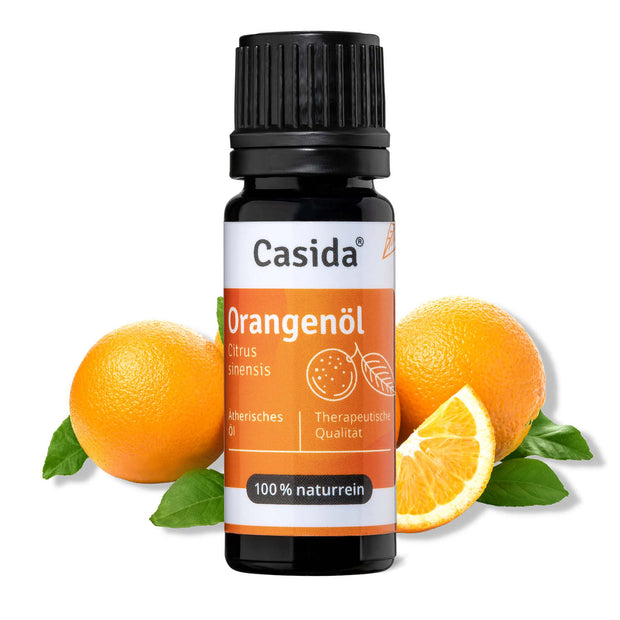 Casida Orangenöl bottle with black cap, surrounded by whole and sliced oranges and green leaves.