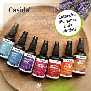 Sieben Casida Raumsprays in verschiedenen Duftrichtungen auf einer Holzschale