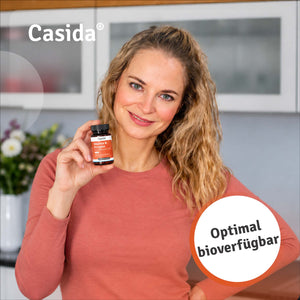 Frau präsentiert eine Dose Casida Vitamin B Komplex mit Coenzym Q10