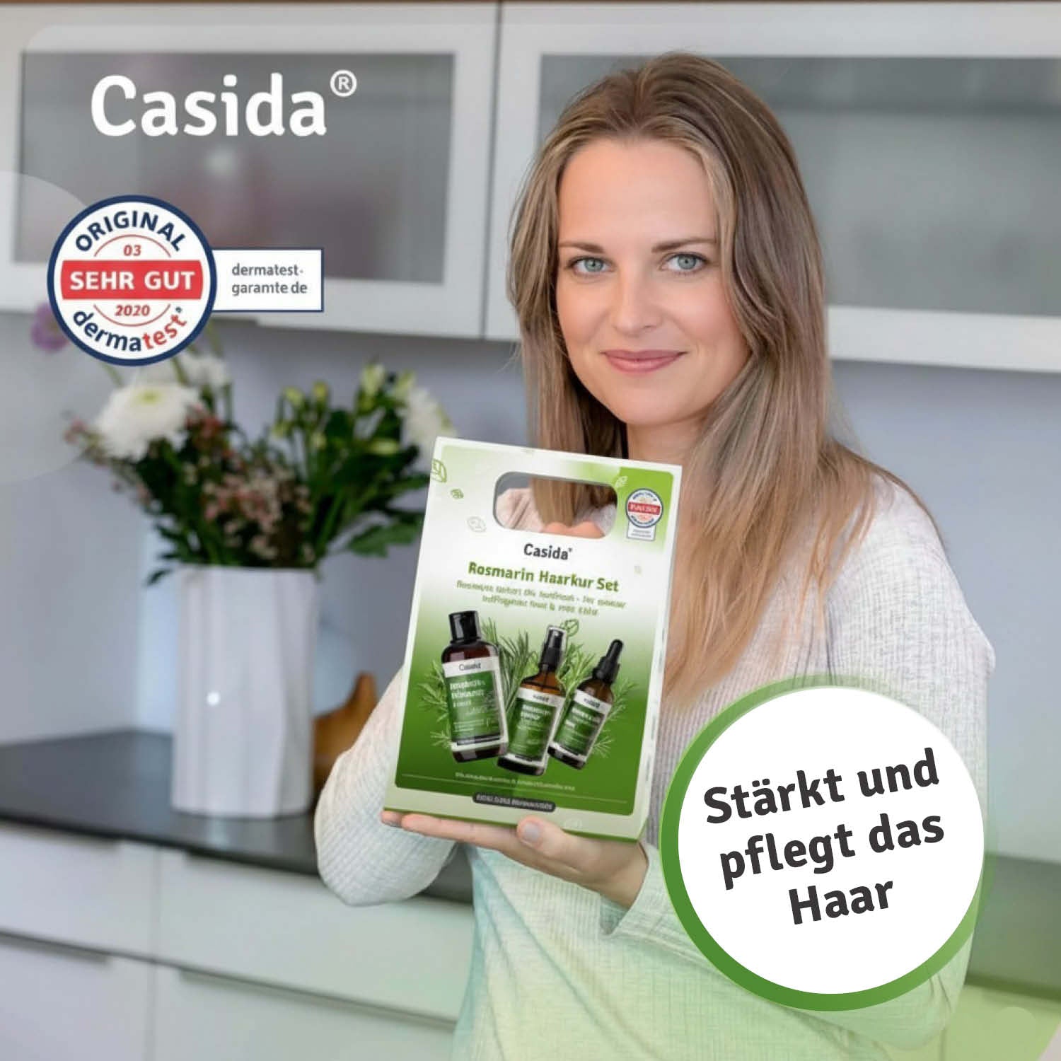 Casida Rosmarin Haarkur set displayed by a woman in a kitchen, featuring hair care bottles and a green box.