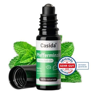 Casida roll-on with peppermint oil, featuring a black cap and green label, placed on fresh mint leaves.
