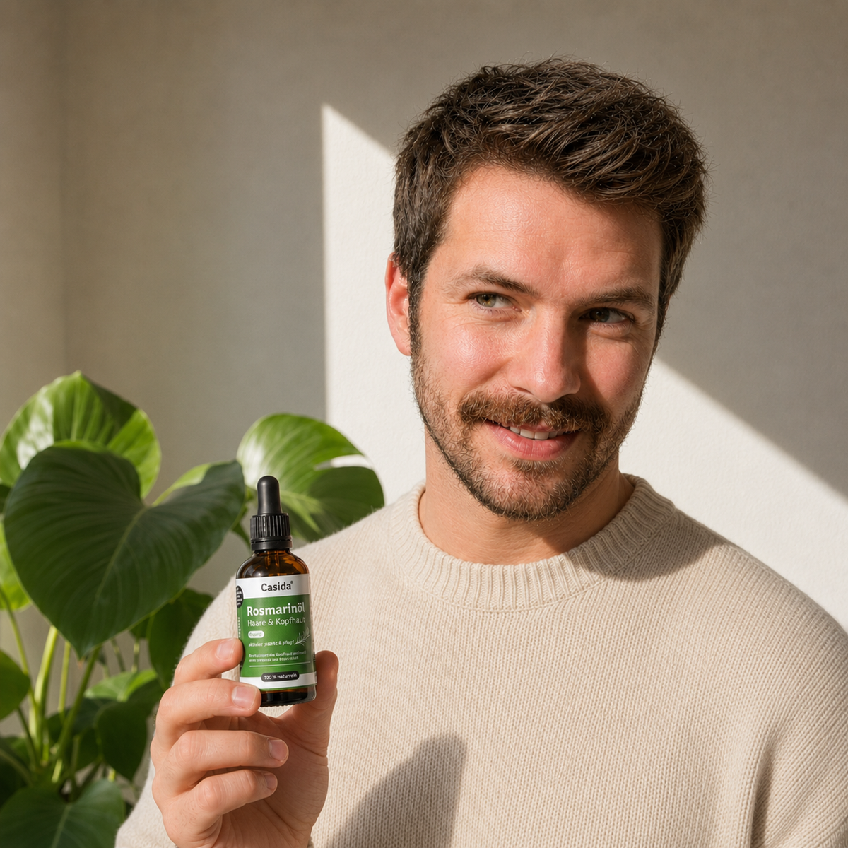 Lächelnder Mann hält eine Flasche Casida Rosmarinöl.