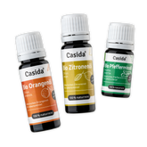 Set of three organic essential oils: lemon, orange, and peppermint in dark bottles with labels.