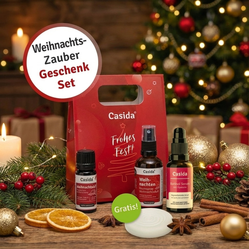 Casida Weihnachtszauber-Set mit Duftöl, Spray, Serum und Duftstein vor einem geschmückten Weihnachtsbaum