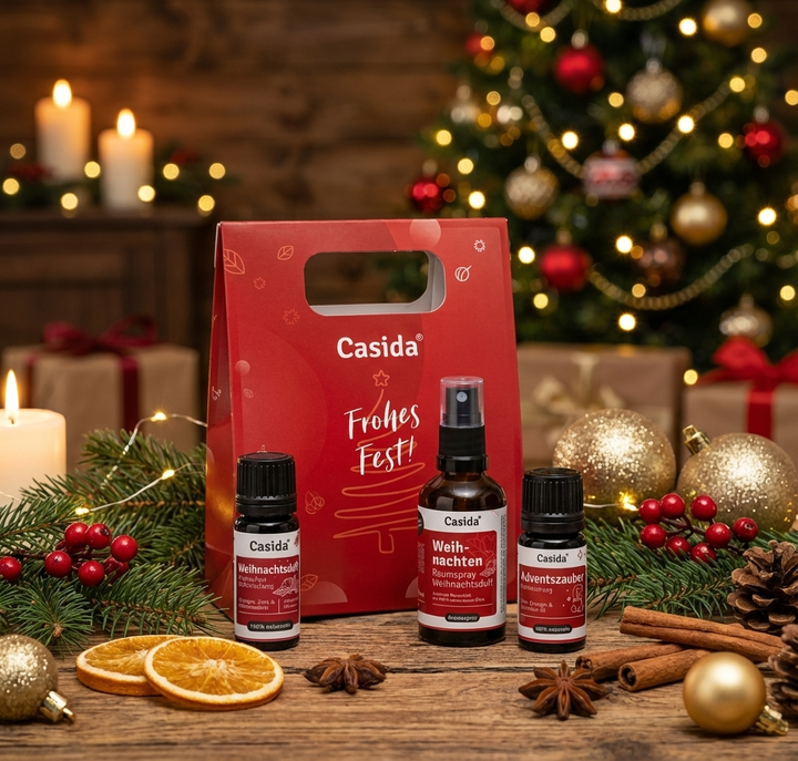 Casida Adventszauber-Geschenkset vor Weihnachtsbaum, Kerzen und Zimtstangen